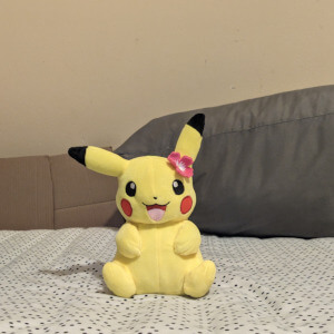 pikachu plushie with a pink flower on head